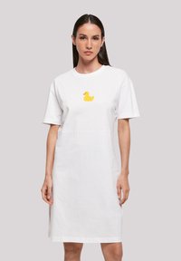 Weißes Baumwoll-T-Shirt-Kleid mit lässiger Passform. Mit einem gelben Gummienten-Graphic auf der Brust. Kurzärmlig und knielang.
