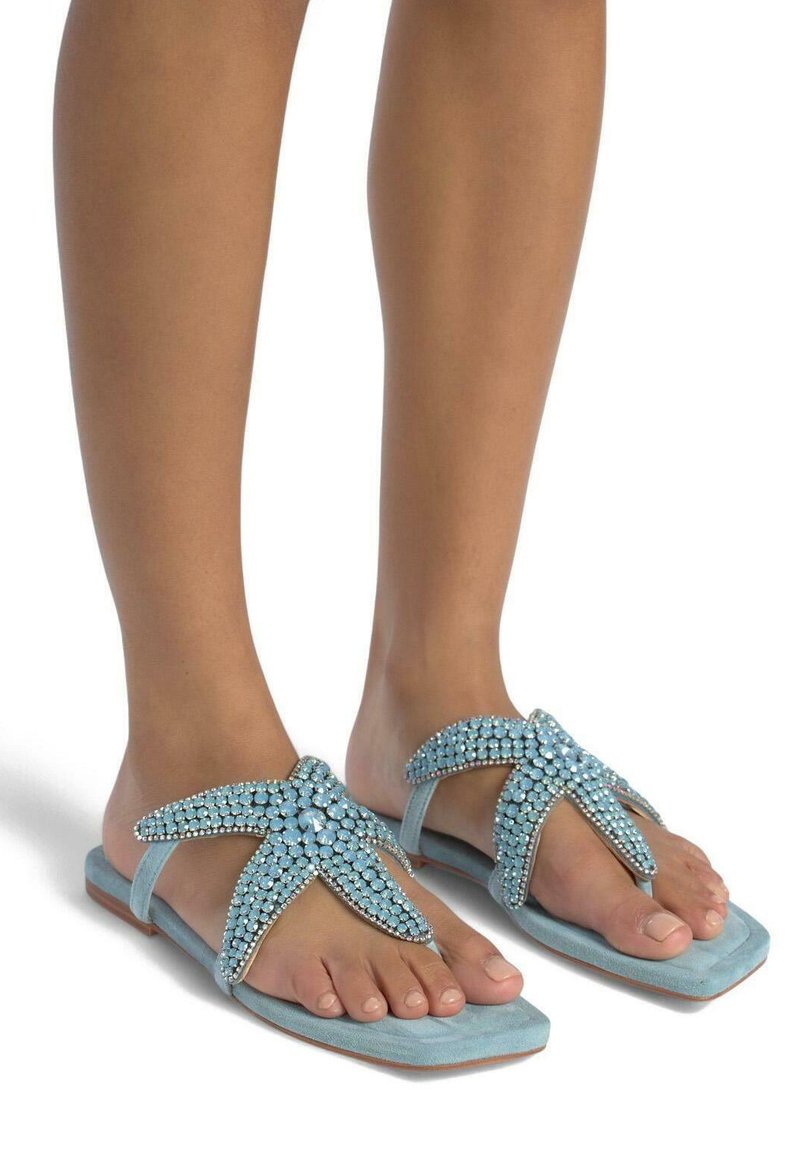 Sandali piatti azzurri con accenti di gioielli in design di stelle marine; materiale in suede morbido, con punta aperta e suola di forma quadrata.
