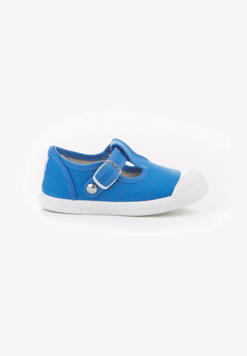 Zapato infantil de lona azul con puntera de goma blanca, correa ajustable y detalles de costura en contraste. Diseño ligero con suela texturizada.