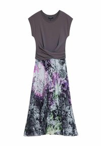 Graues Oberteil mit kurzen Ärmeln und einem gedrehten Detail an der Taille, das in einen farbenfrohen, abstrakten Rock mit Blumenmuster in Lila, Schwarz und Grün übergeht.