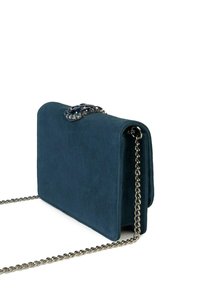 Sac à main en daim couleur vert sarcelle foncé avec une bandoulière chaîne argentée et un fermoir orné de bijoux. Présente une forme rectangulaire structurée et une texture lisse.