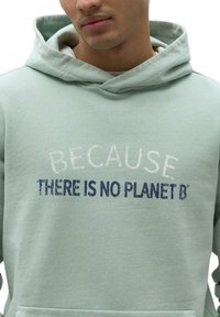 Sudadera de color verde claro con bolsillo tipo canguro, capucha con cordón y texto que dice "PORQUE NO HAY UN PLANETA B" en colores contrastantes.