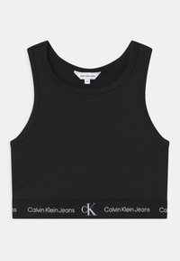 Czarny bawełniany crop top z okrągłym dekoltem i szerokimi ramiączkami. Posiada elastyczny pasek z logo "Calvin Klein Jeans" w białym kolorze.