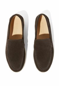 Brune ruskind slip-on sko med en rund tå, kontrasterende syninger og en cremefarvet sål. Minimalistisk design uden yderligere udsmykninger.