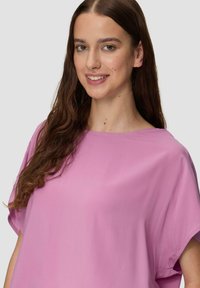 Roze T-shirt met korte mouwen, een losse, relaxte pasvorm en een ronde halslijn. Zachte, gladde textuur met een effen kleur en een minimalistisch ontwerp.