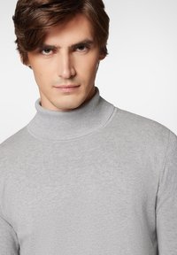 Jasnoszary, prążkowany sweter typu golf z dopasowaną sylwetką i gładką teksturą, z wysokim kołnierzem i długimi rękawami.