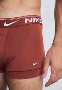Nike herre boxer brief i dyp rød stoff, med hvitt logo på midjebåndet og en mindre logo på benet, med en tettsittende passform.