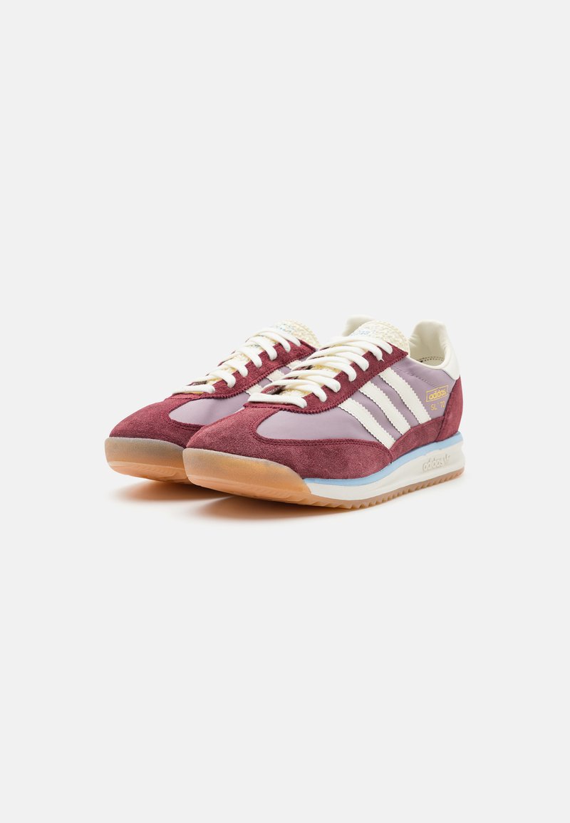 Baskets en suède bordeaux avec des accents violet clair, des rayures blanches et une languette en crème texturée. Semelle en caoutchouc gomme au design rétro.