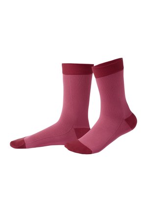 Paar mittellanger Rippstrümpfe in Pink mit dunkler roten Bündchen, Fersen und Zehen vor weißem Hintergrund.