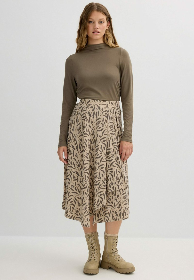 Falda midi de diseño floral en color beige combinada con una blusa de manga larga en tono oliva y botas de cordones color marrón claro; tela suave, diseño fluido y textura sutil.