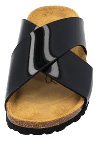 Sandalia deslizante de charol negro con correas entrecruzadas, plantilla de ante, suela de corcho y suela exterior de goma texturizada. Diseño plano, estilo casual.