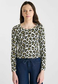 Geribbelde lange mouwen top met ronde halslijn, voorzien van een luipaardprint in zwart en olijf op een crèmekleurige achtergrond; gecombineerd met donkere denim.