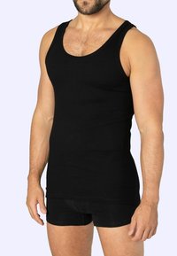 Black ribbed tank top with wide straps, fitted design, and soft texture, paired with black shorts. Simple, versatile look.