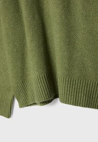 Olivgrüner Pullover mit weicher Textur, der über einen gerippten Saum und Bündchen verfügt. Das Material wirkt warm und leicht, ideal zum Übereinandertragen.