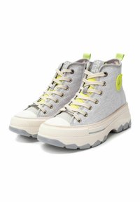 Zapatillas altas de tela gris claro con acabado texturizado, puntera de goma blanca, suela gruesa y acentos y cordones en amarillo neón.