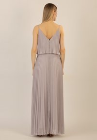 Helles Lavendel, plissiertes Maxikleid mit V-förmigem Rücken und dünnen Trägern. Verfügt über eine geraffte Taille und einen Reißverschluss hinten.