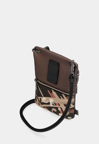 Braune, strukturierte Leder-Umhängetasche mit einem gemusterten unteren Bereich. Sie verfügt über ein Reißverschlussfach, einen verstellbaren Schultergurt und kontrastierende Hardware-Akzente.