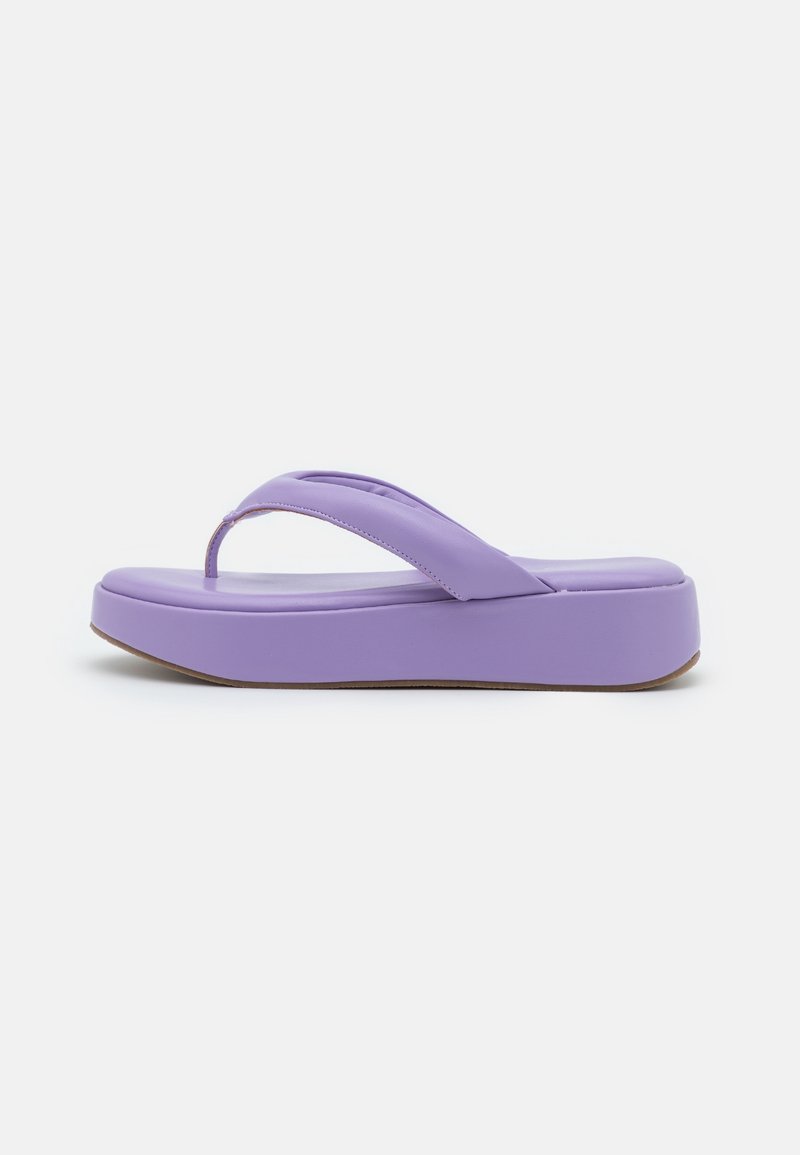 Des tongs violettes avec une semelle épaisse, présentant une lanière supérieure lisse et un design en entre-doigts ; texture minimale et sans motifs visibles.