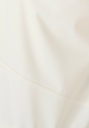 Tissu blanc présentant une texture lisse et une légère brillance, avec un détail de couture horizontale et un léger effet de drapé.