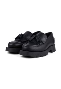 Black leather loafers with a textured finish, featuring a thick rubber platform sole, and decorative tassel accents on the front.