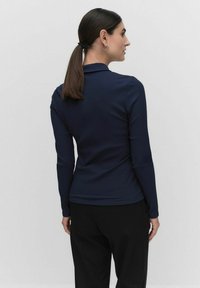 Merenkaan ribbed pitkähihainen paita, jossa on muotoiltu kaulus, tiukka malli, sileä pinta ja huomaamattomat ompeluyksityiskohdat helmassa.