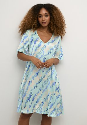 Kurzarm, V-Ausschnittkleid in Hellblau mit abstrakten Mustern in Blau- und Pfirsichtönen. Fließender Stoff, knielanges Design.