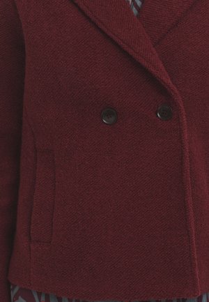 Bordeauxfarbene, doppelt geknöpfte Jacke aus strukturiertem Stoff, mit zwei schwarzen Knöpfen und einer Seitentasche.