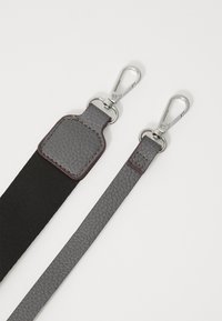 Bracelet en cuir gris avec finition texturée, doté de fermoirs métalliques argentés et d'une section élastique noire pour plus de flexibilité.