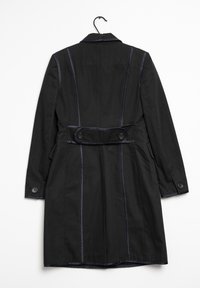 Cappotto nero con un design strutturato, caratterizzato da un colletto, polsini con bottoni e una vita con cintura. La cucitura a contrasto lungo le cuciture aumenta il dettaglio.