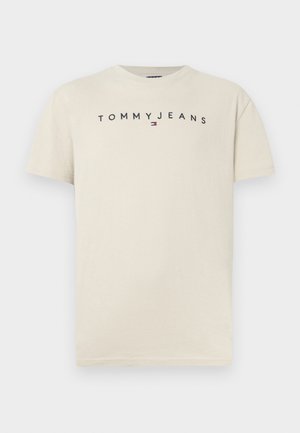 Világos bézs színű pamut póló rövid ujjakkal, kerek nyakkal, fekete "TOMMY JEANS" logóval a mellkas közepén, kicsi piros és kék emblémával.