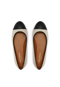 Ballerinas mit einer schwarzen Kappe und einem cremefarbenen Obermaterial. Glattes Leder und eine beige Innensohle mit Markenbeschriftung. Abgerundete Form, minimalistisches Design.