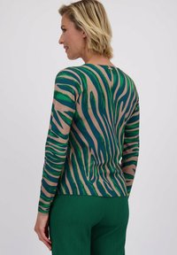 Lange mouwen top in beige met groene en blauwe zebra strepen. Slanke pasvorm, ronde hals, ribstructuur en licht gebogen zoom.