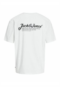 Camiseta de algodón blanca con mangas cortas y cuello redondo. La parte posterior presenta un logo de marca impreso en negro y texto en una fuente de escritura casual.