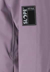 Giacca viola chiaro con design elegante, texture del tessuto e un'etichetta nera "SLOPE" ben in evidenza sulla manica.