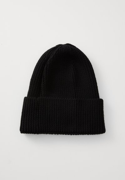 Svart stickad mössa med ribbat mönster, med en vikbar kant i nederkant, tillverkad av ett mjukt, elastiskt material.