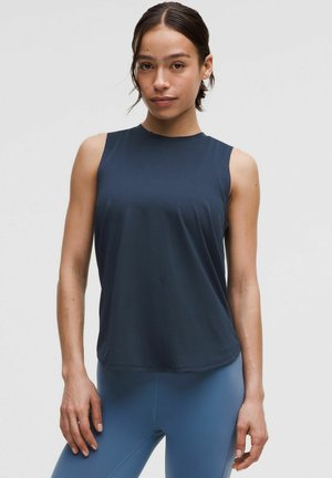 Haut de sport sans manches bleu marine avec un col rond, fabriqué à partir d'un tissu lisse et léger, accompagné de leggings bleus clairs.