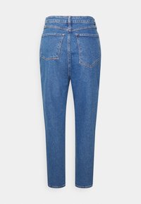 Svetle modré džíny z denimu s vysokým pasem, rovnými nohavicemi, dvěma zadními kapsami a decentními detaily šití. Hladký lem s minimální texturou.