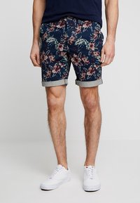 Marinblå shorts med blommönster och upprullade fållar, tillverkade av bomullstyg. Har knapp- och dragkedjestängning samt fickor på sidorna.