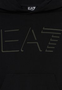 Crna dukserica s kapuljačom koja se ističe velikim EA7 logotipom u maslinastoj boji. Napravljena od mekane tkanine s prednjim džepom.