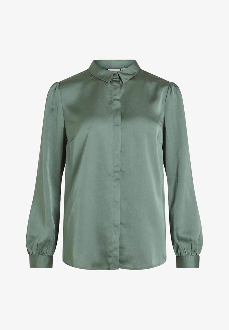 Blouse verte en satin avec un col classique, des manches longues bouffantes et une fermeture boutonnée à l'avant. Elle présente une texture lisse et une coupe ajustée.