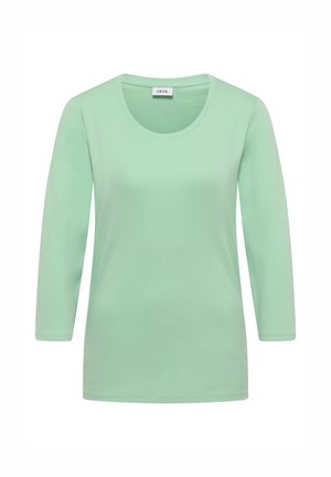 Camiseta de manga larga para mujer en verde claro con escote redondo y etiqueta "CECIL" en el cuello.