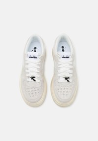 Sneaker bianche con una tomaia in suede testurizzato e dettagli perforati. Presentano lacci bianchi, un accento del logo nero e una suola color crema.