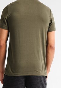 Short-sleeve olive green t-shirt made of soft fabric, featuring a simple crew neck and a relaxed fit. No distinctive patterns or accents.