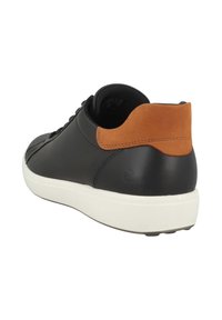 Sneaker in pelle nera con linguetta in suede marrone, suola in gomma bianca e punta rotonda, dotato di lacci e texture liscia.