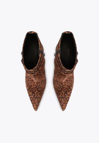 Brown leopard print ankle boots with pointed toes, gathered design at the ankle, and decorative silver hardware at the side.