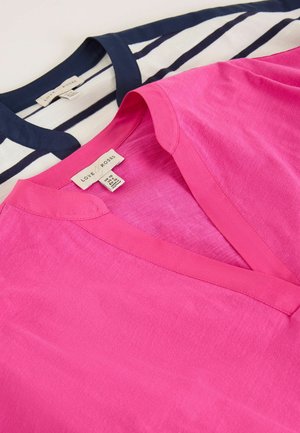 Kaks kokkupandud Love & Roses kaubamärgi topi, üks helepunase ühevärvilise V-kaelusega ja teine valge tumesiniste horisontaalsete triipude ning tumesinise kraega.