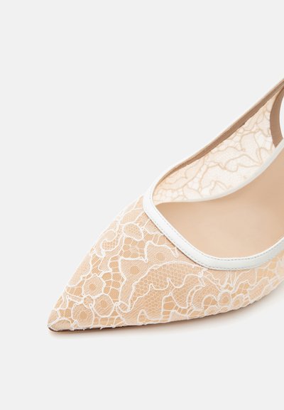 Chaussure plate beige pointue avec superposition en dentelle blanche et bordure blanche autour de l'ouverture, présentée sur un fond clair uni.