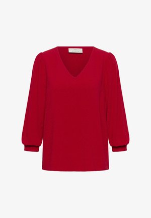 Haut en tricot rouge avec un col en V, des manches bouffantes trois-quarts et une finition texturée. Ourlet droit et poignets élastiques complètent le design.