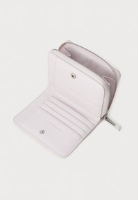 Calvin Klein lompakko pehmeästä vaaleanpunaisesta nahasta, vetoketjukiinnitys, useita korttipaikkoja ja napillinen lokero. Tasainen pinta hopeisilla yksityiskohdilla.