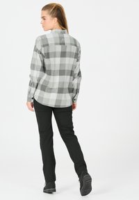 Grå og hvid plaid skjorte med knaplukning, lange ærmer med manchetter, parret med sorte slim-fit bukser og mørke sko. Rent design, blød tekstur.